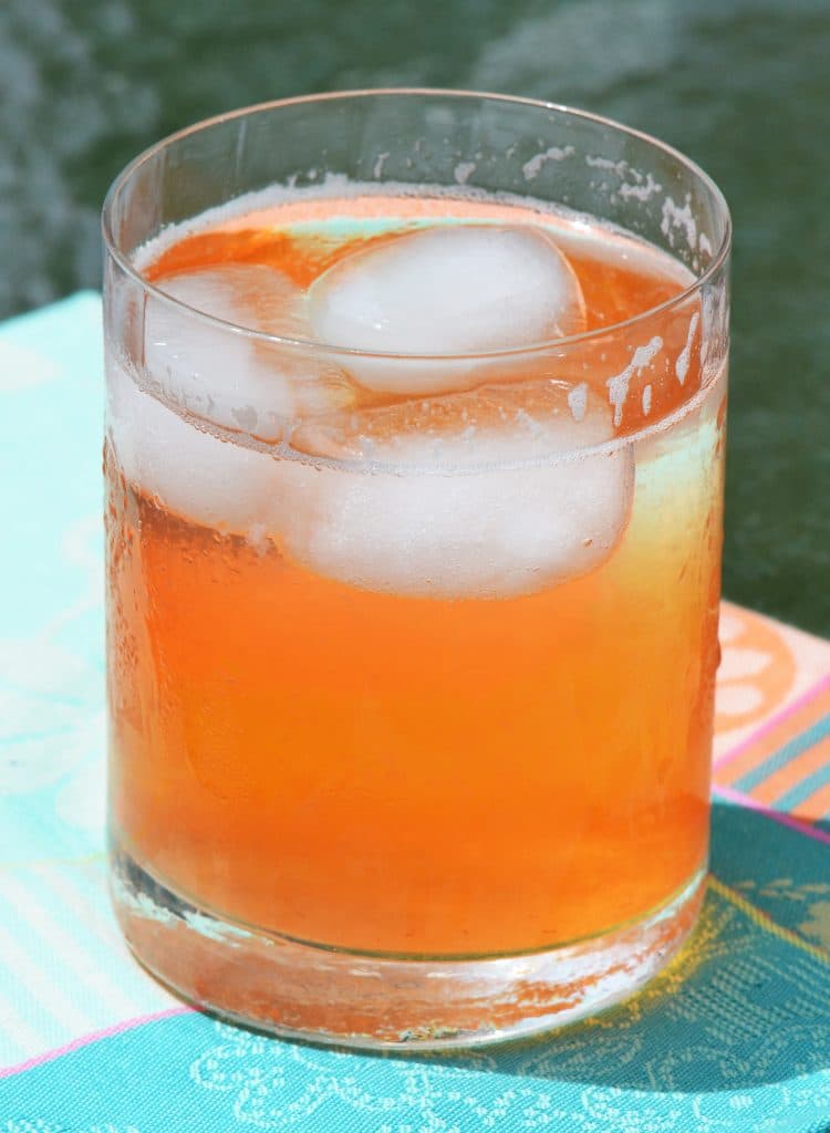 Strawberry rose lemonade in an iced glass on a blue napkin, in summer sun, Maureen Abood.com