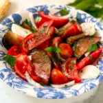 Tomato Salad in a blue and white bowl with mint on the side