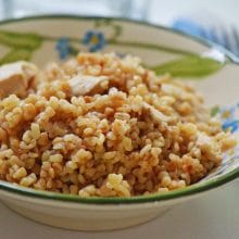 Golden brown chicken bulgur pilaf in a bowl with green and blue trim