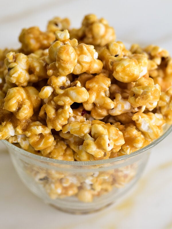 Caramel corn in a glass bowl on a marble counter