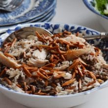 Lebanese hushweh, chicken rice pilaf in a blue and white bowl with a spoon