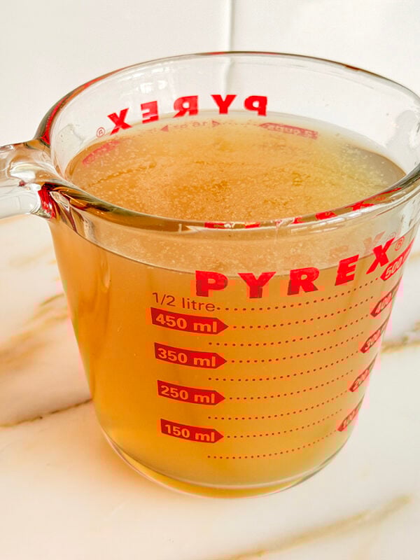 Chicken stock in a pyrex measuring cup