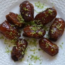 Warm Almond Stuffed Dates with Lime Zest on a round white plate