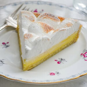A slice of lemon meringue tart on a flowered plate