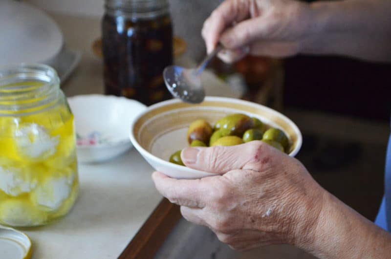 A hand holding a bowl and mixing with a spoon.