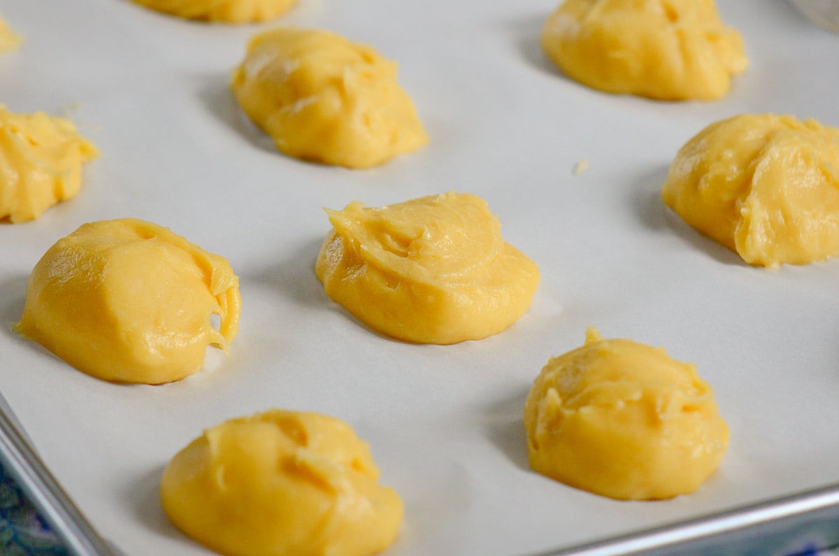 Choux paste dough on a parchment lined baking sheet