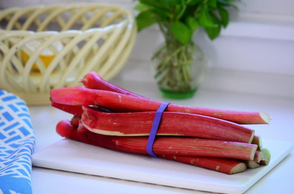 A bundle of rhubarb on a white cutting board