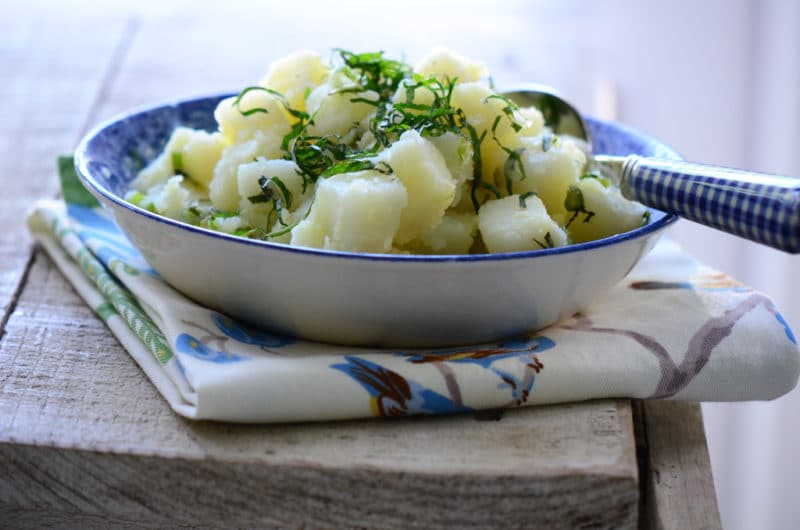 Lebanese potato salad with lemon and mint, in a lovely blue bowl with blue gingham spoon, by Maureen Abood.com