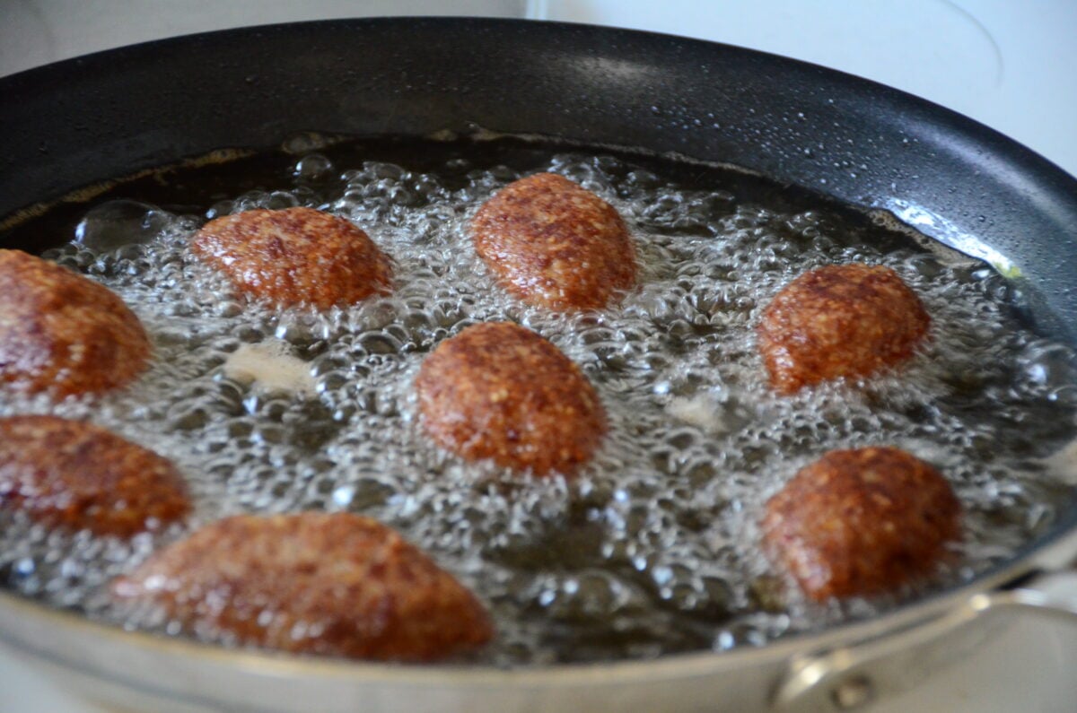 Kibbeh balls frying in a pan