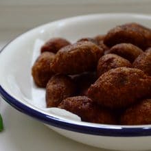 Kibbeh Footballs piled on a white platter with blue trim