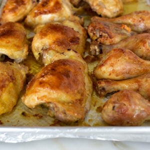 Golden brown Oven fried chicken thighs and drumsticks on a sheet pan