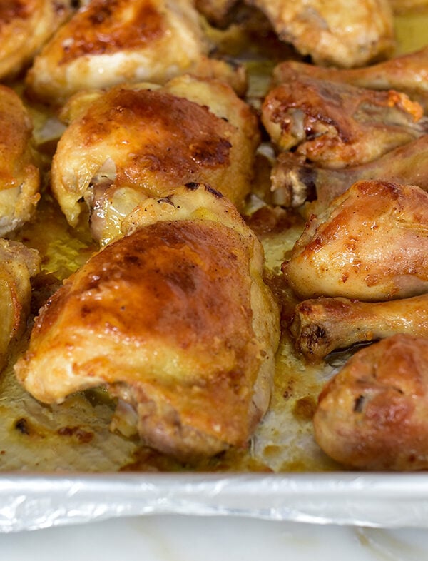 Golden brown Oven fried chicken thighs and drumsticks on a sheet pan