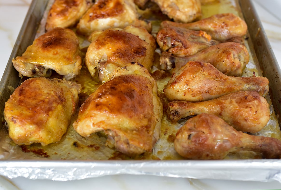 Golden brown Oven fried chicken thighs and drumsticks on a sheet pan