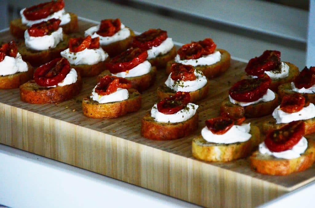 Za'atar roasted tomato crostini with labneh on a wooden board, Maureen Abood
