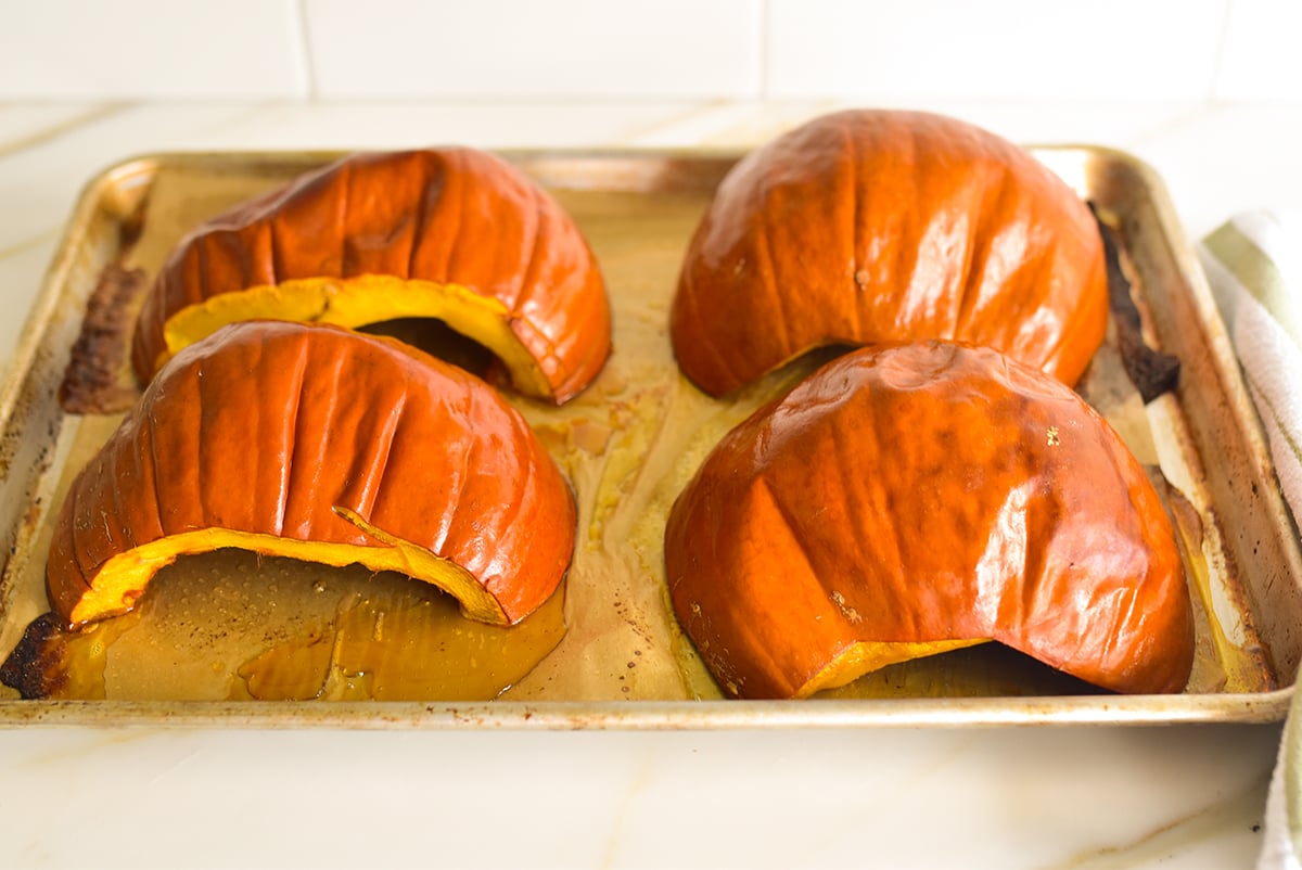 roasted halved pumpkins on a baking sheet 