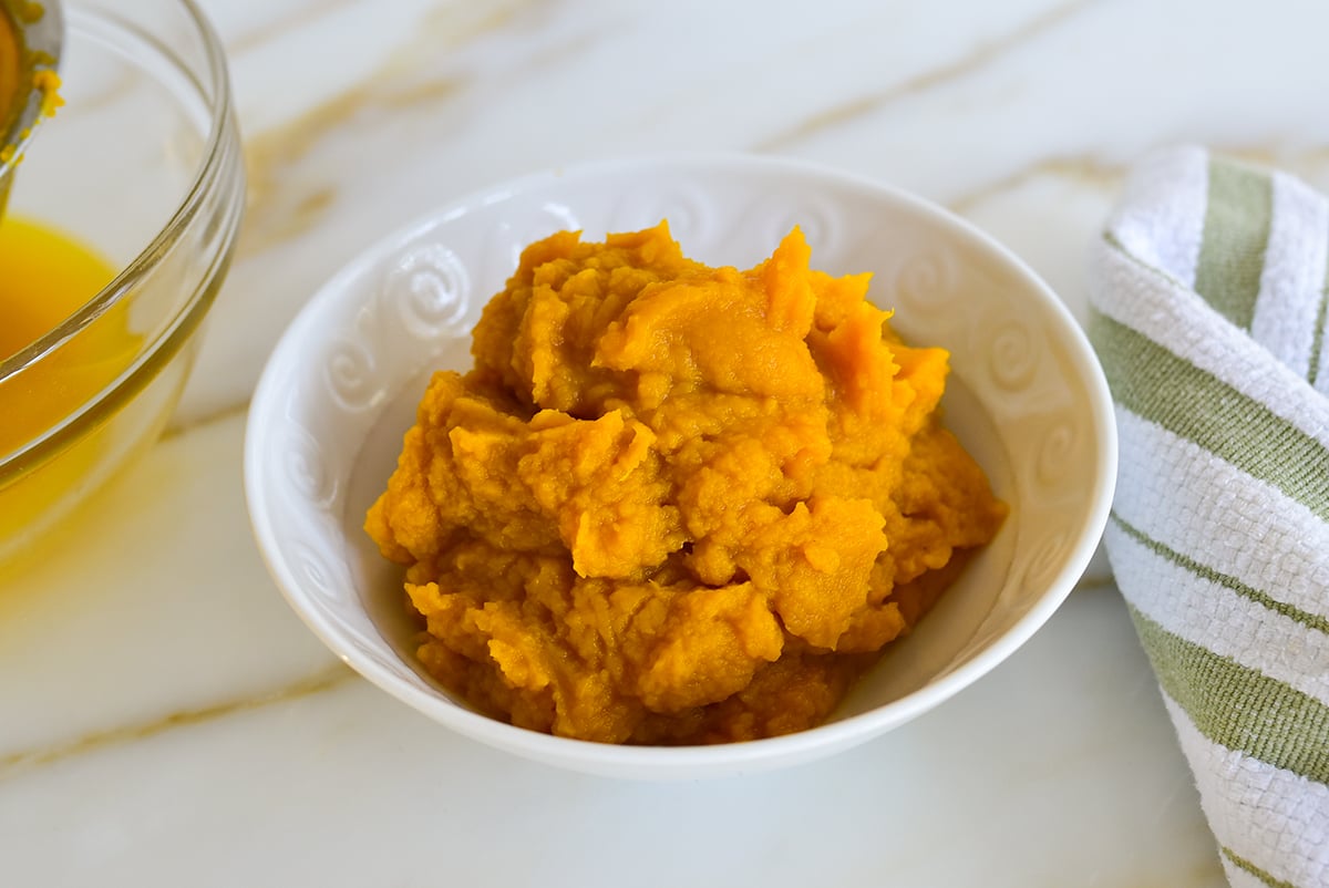 Pumpkin puree in a white bowl on the counter