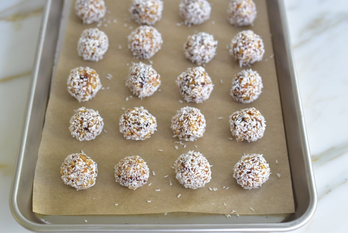 Coconut date balls on a parchment lined sheet pan