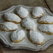 Diamond-shaped butter cookies with powdered sugar on a round plate