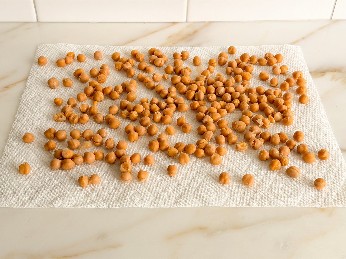 chickpeas drying out on a paper towel on a marble countertop