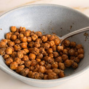 Crispy roasted chickpeas in a blue bowl with a spoon