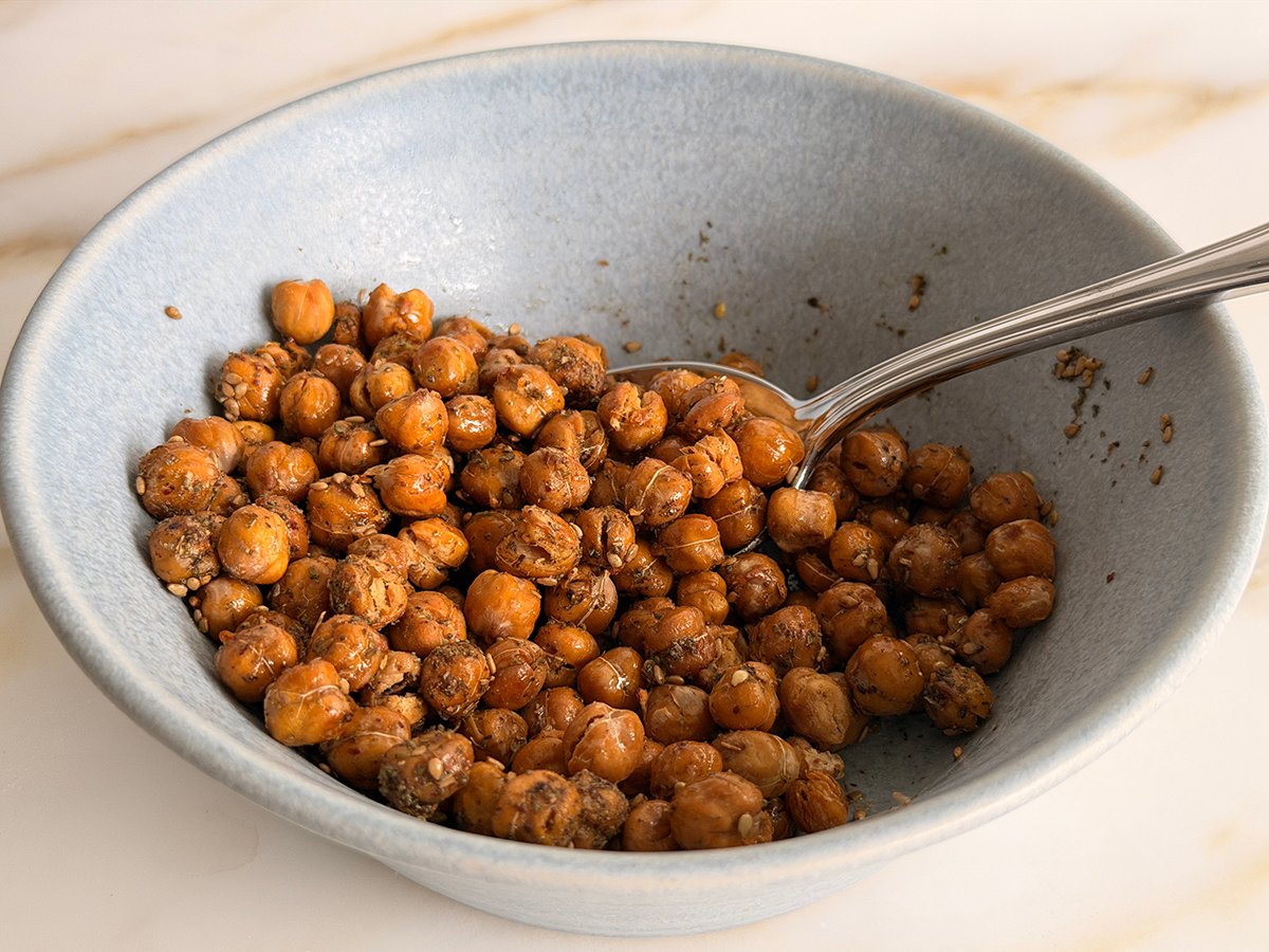 Crispy roasted chickpeas in a blue bowl with a spoon