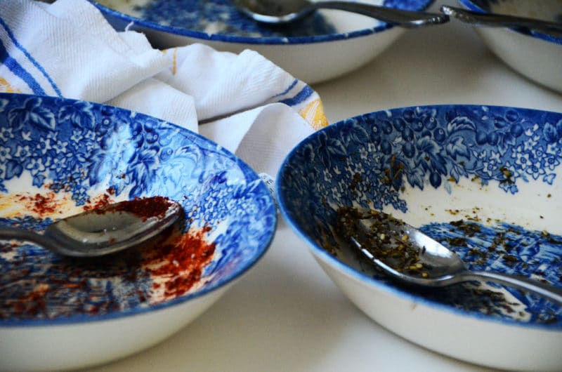 Two blue dishes with silver spoons.