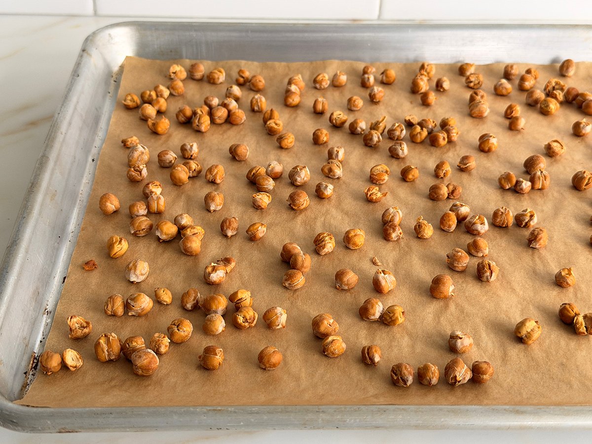 roasted chickpeas on parchment paper on a baking sheet