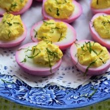 Deviled eggs on a blue plate lined with a doilie.