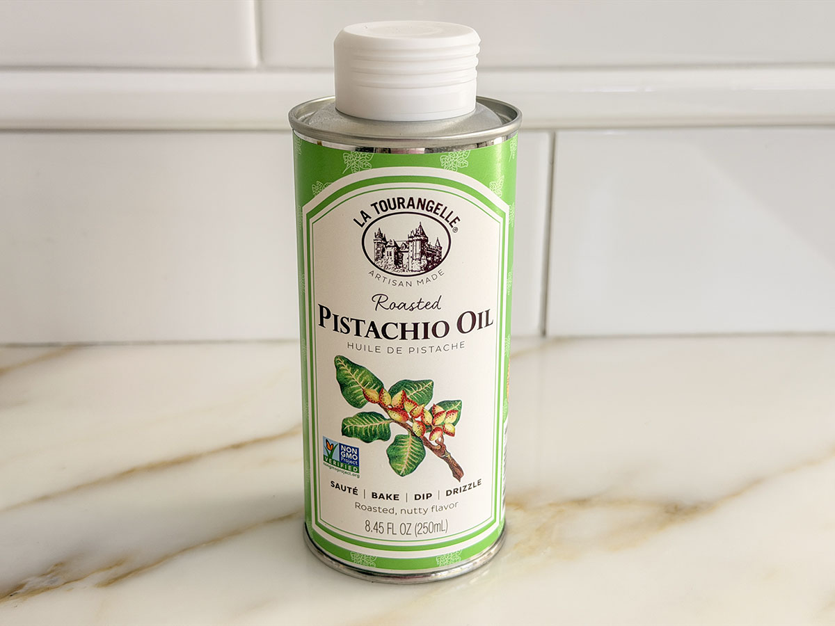 La tourangelle pistachio oil in a green can on a marble countertop