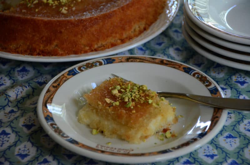 A slice of Lebanese knafeh pastry on a white plate with a fork.