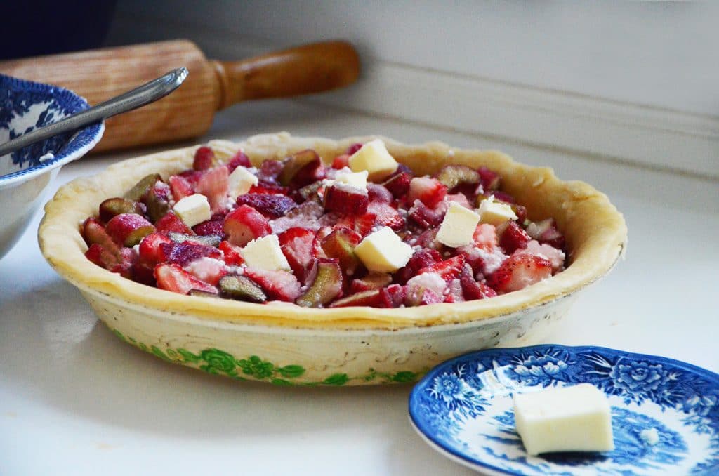 Pie filling with butter pieces in a pie plate