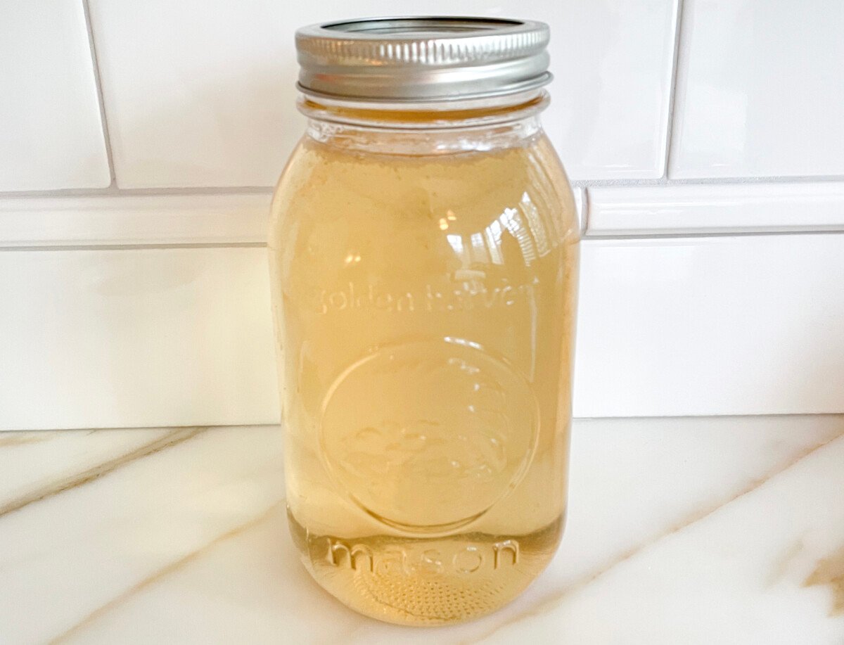 Simple syrup in a mason jar on a marble countertop