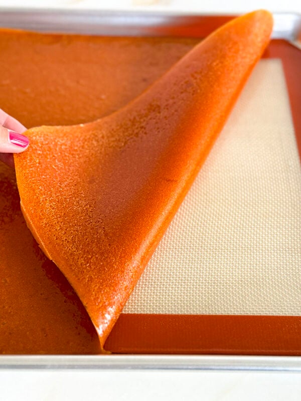 apricot fruit leather pulled back from a silpat with a hand