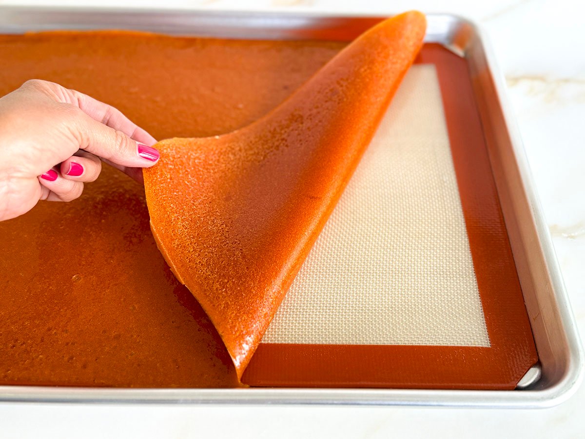 apricot fruit leather pulled back from a silpat with a hand