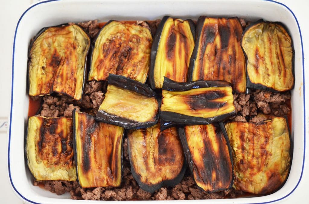 Golden eggplant slices in a white baking dish