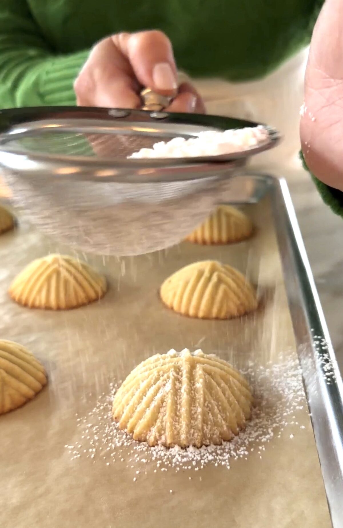 Mamoul cookies with confectioners' sugar in a sieve over top