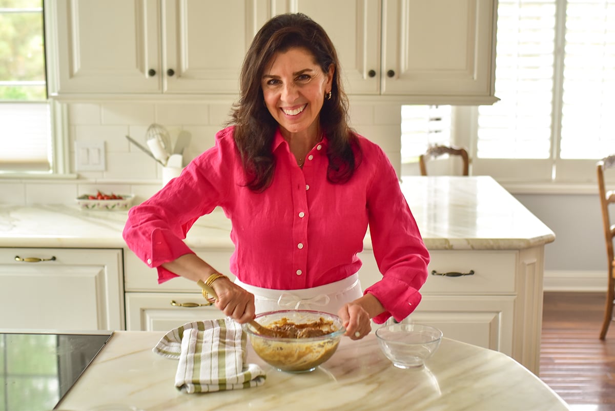 Maureen Abood standing in the kitchen stirring ingredients in a bowl