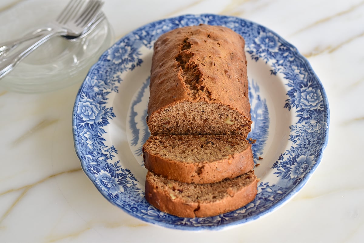 Sliced Date Nut Bread loaf on a blue and white platter