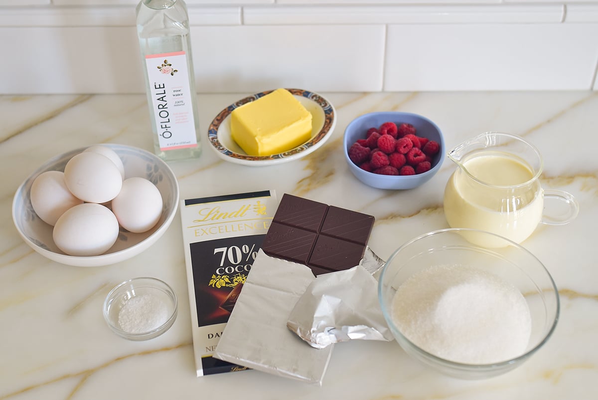 Ingredients for chocolate torte with whipped cream on a marble countertop