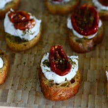 Zaatar roasted tomato crostini with labneh, on a board