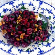 Cherry and walnut salad with green parsley in a blue and white bowl