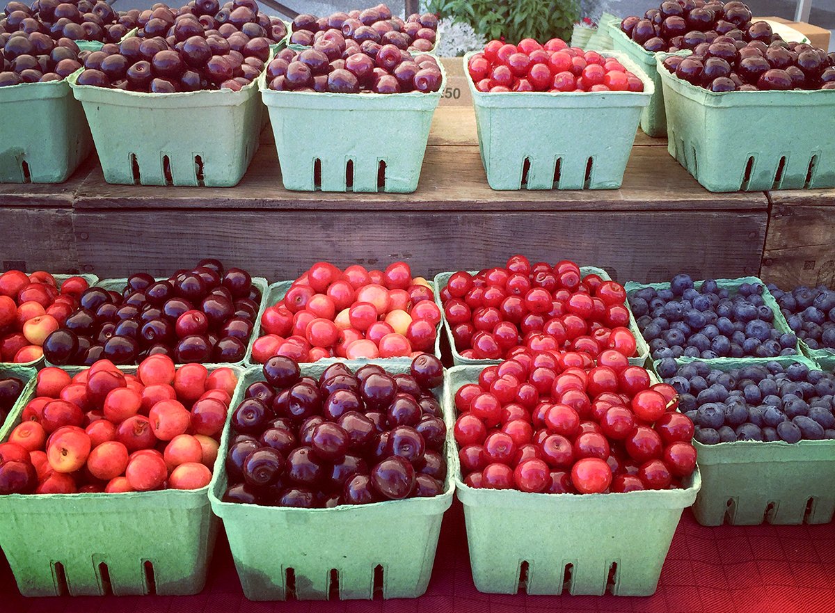 Display of cherries in green quart boxes at the farmer's market
