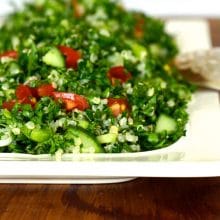 Bright green Quinoa Tabbouleh on a white rectangular platter