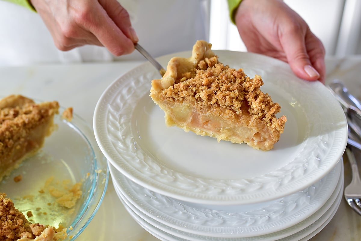 Slice of apple pie on a white plate