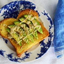 Salted Tahini Avocado Toast on a blue floral plate with blue linen napkin.