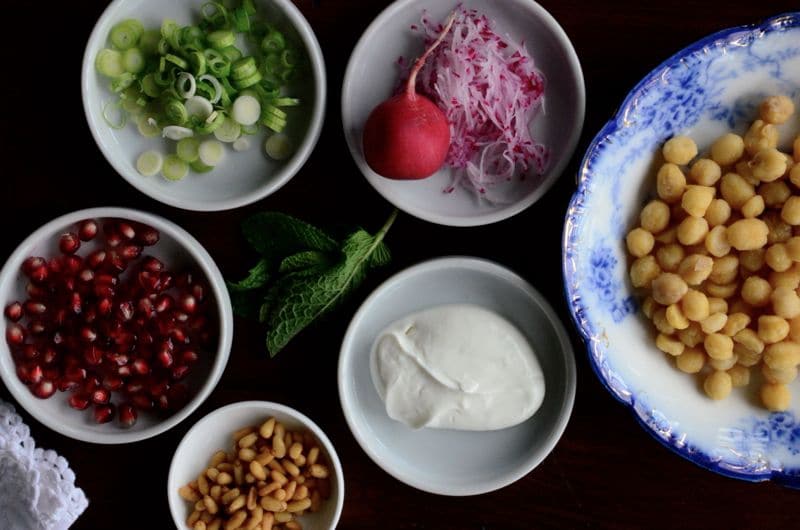 ingredients for Lebanese fatteh in small bowls of labneh, chickpeas, radish, pine nuts