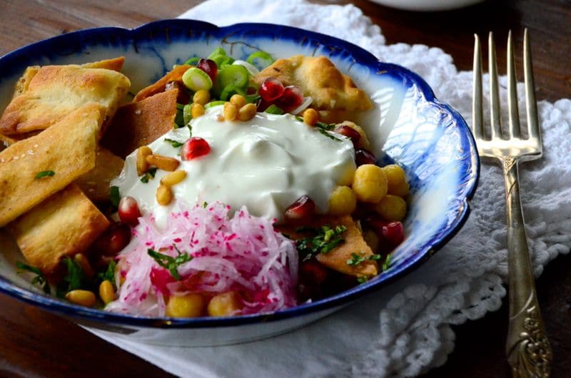 Lebanese fatteh in a blue bowl with a fork alongside