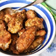 Za'atar Chicken Wings in a round bowl with blue trim and a silver spoon