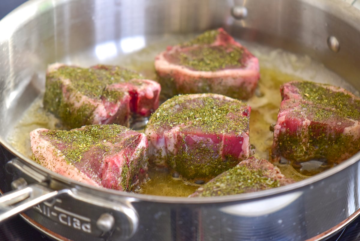 lamb chops coated with dried mint in a saute pan