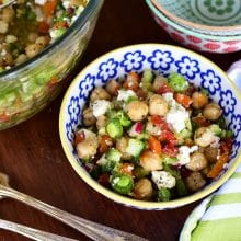 Chickpea salad with tomatoes and feta in a blue and white bowl with a fork on the side